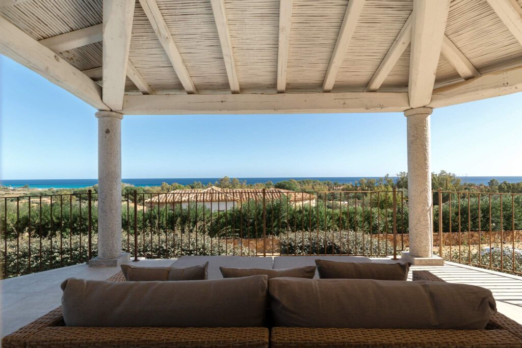 Elegante porticato in legno di Villa Melograno con tavolo da pranzo esterno, affacciato sul mare di Costa Rei